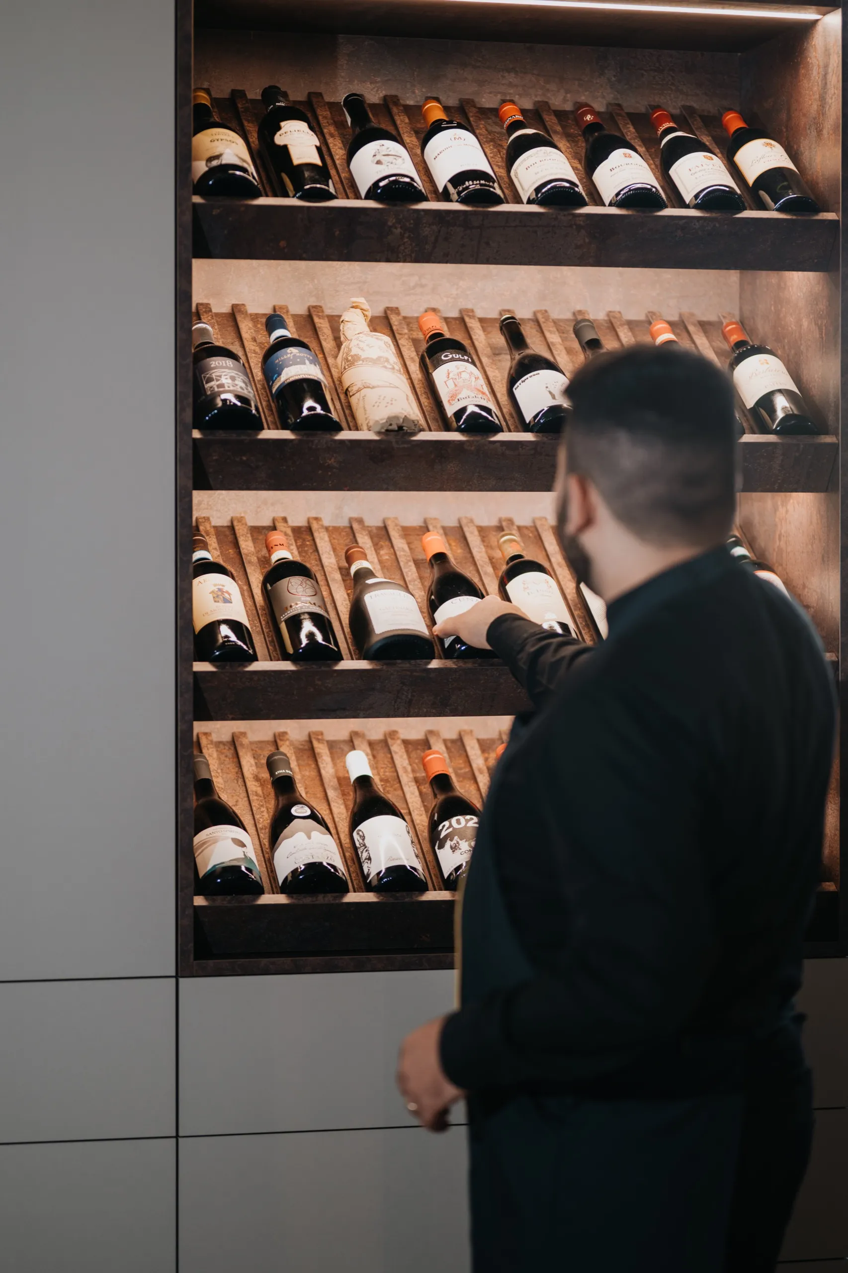 Il maître sceglie una bottiglia in cantina